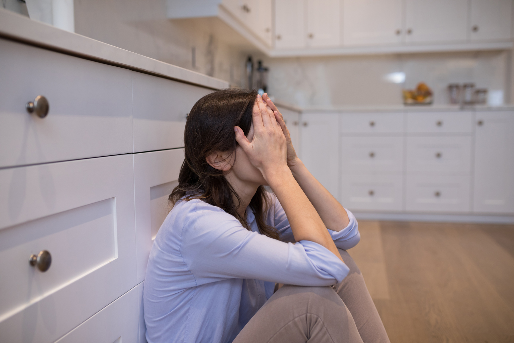 Worried woman sitting in kitchen